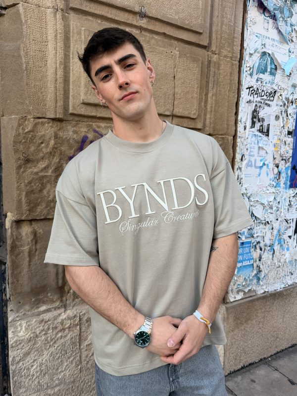 A man wearing the Tierra Streetwear T-shirt with 3D BYNDS embroidery and earth-toned heavy cotton.